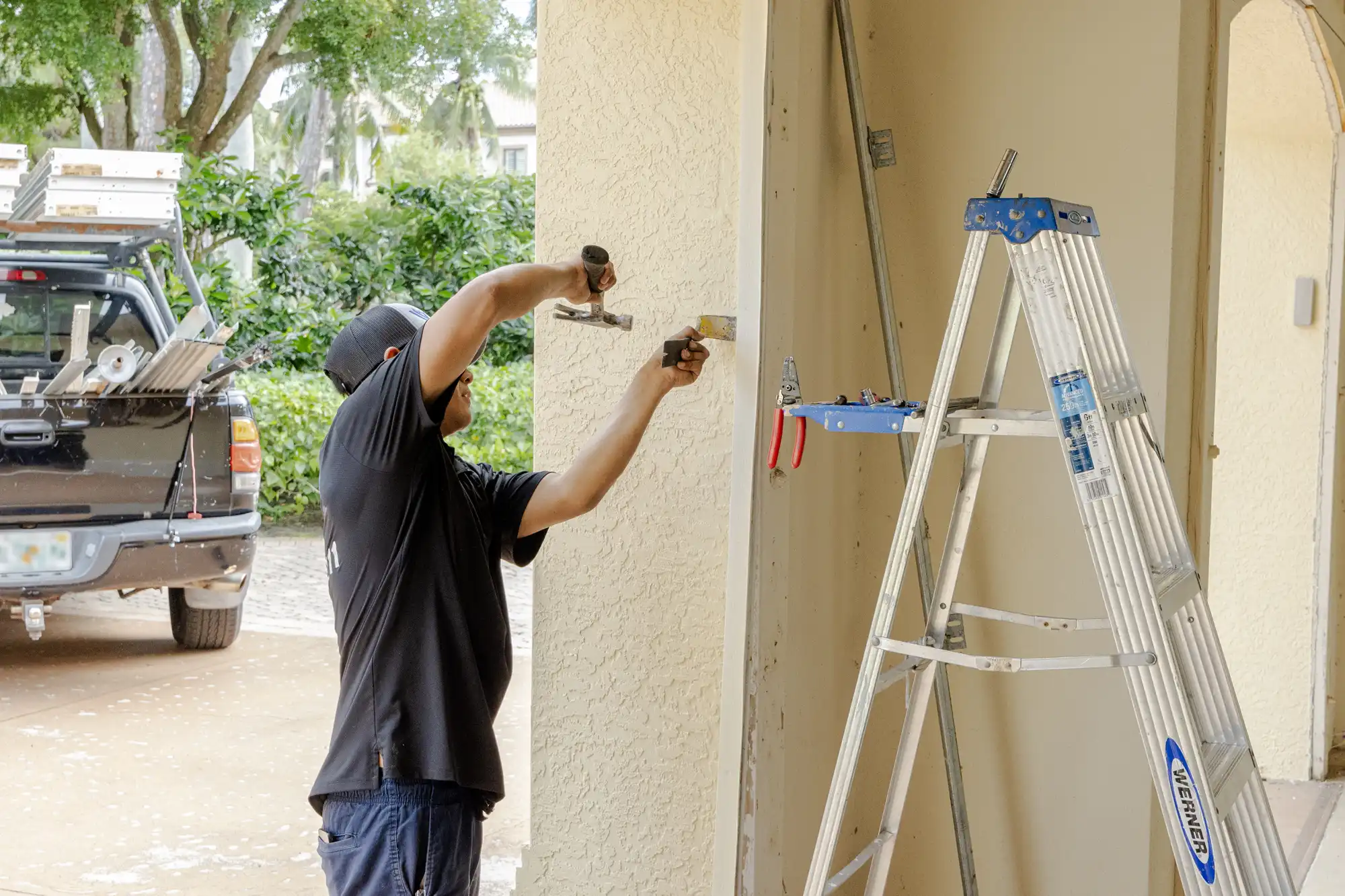 West Bay Garage employee removing trim from garage to install door